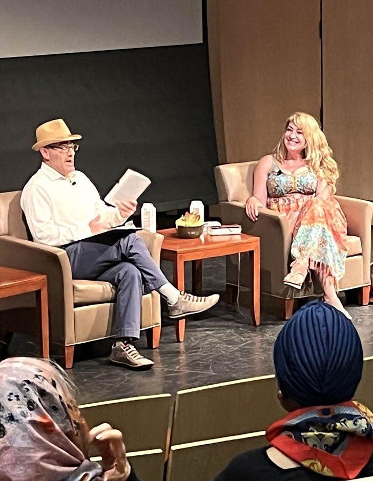 writer michelle dowd sits on the benson stage with phil zuckerman